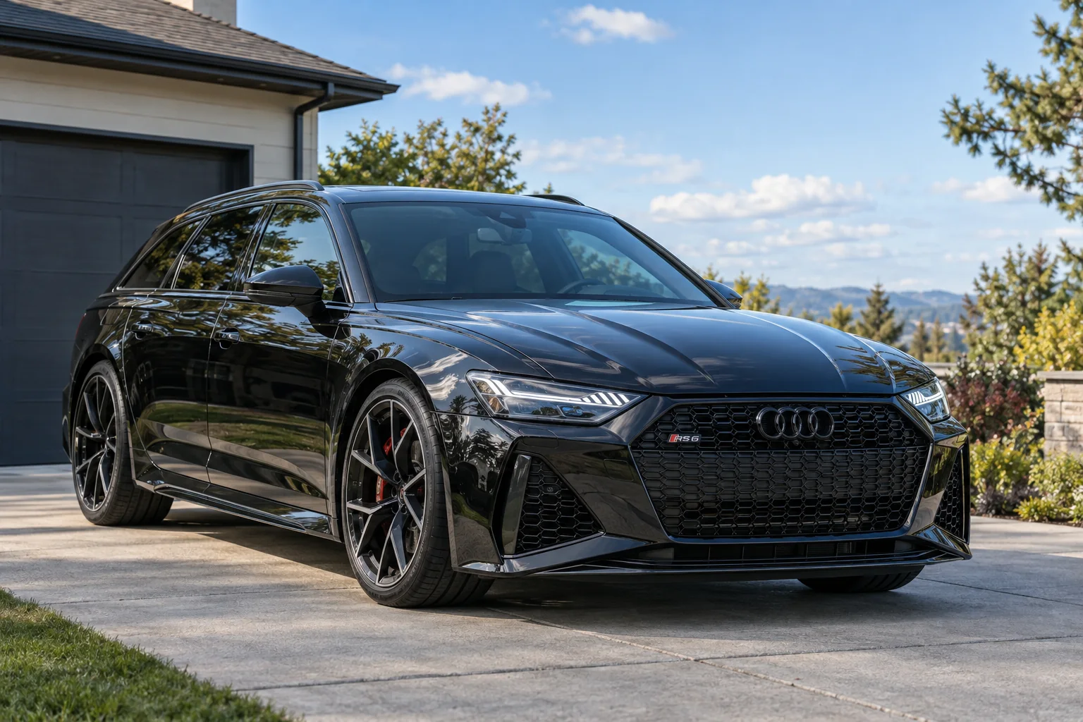 A black Audi RS6 Avant with tinted windows on a driveway